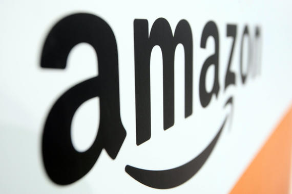 31 Jul 2014, Shanghai, China --- --FILE--The logo of Amazon is pictured at the stand of the American e-commerce giant during an exhibition in Shanghai, China, 31 July 2014. Amazon.com Inc has opened an online store on Alibaba Group Holding Ltd's fast-growing online marketplace, Tmall.com as it seeks to expand in China, an Alibaba spokesman said. Alibaba's Tmall offers virtual storefronts and payment portals to merchants. Several western retailers, including Zara owner Inditex, Britain's Burberry and ASOS, have joined TMall this year as they look to boost their presence in China. Imported food, shoes, toys and kitchenware are listed on Amazon's store, one of the many on Tmall that sell brand-name goods to Chinese shoppers. Amazon also operates its own e-commerce site in China. --- Image by © Imaginechina/Corbis